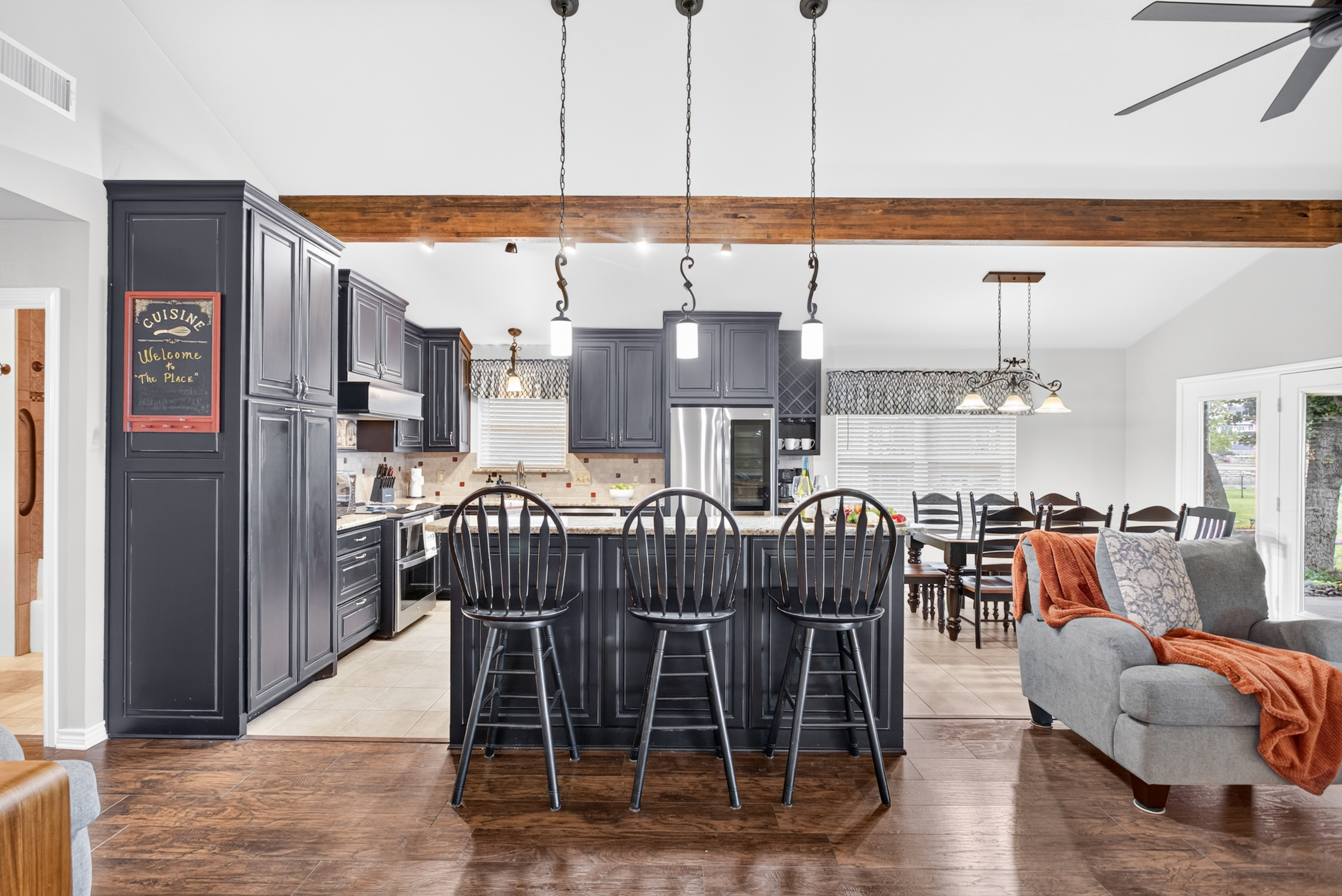 Spacious open kitchen with large island, dining area, and warm designer touches