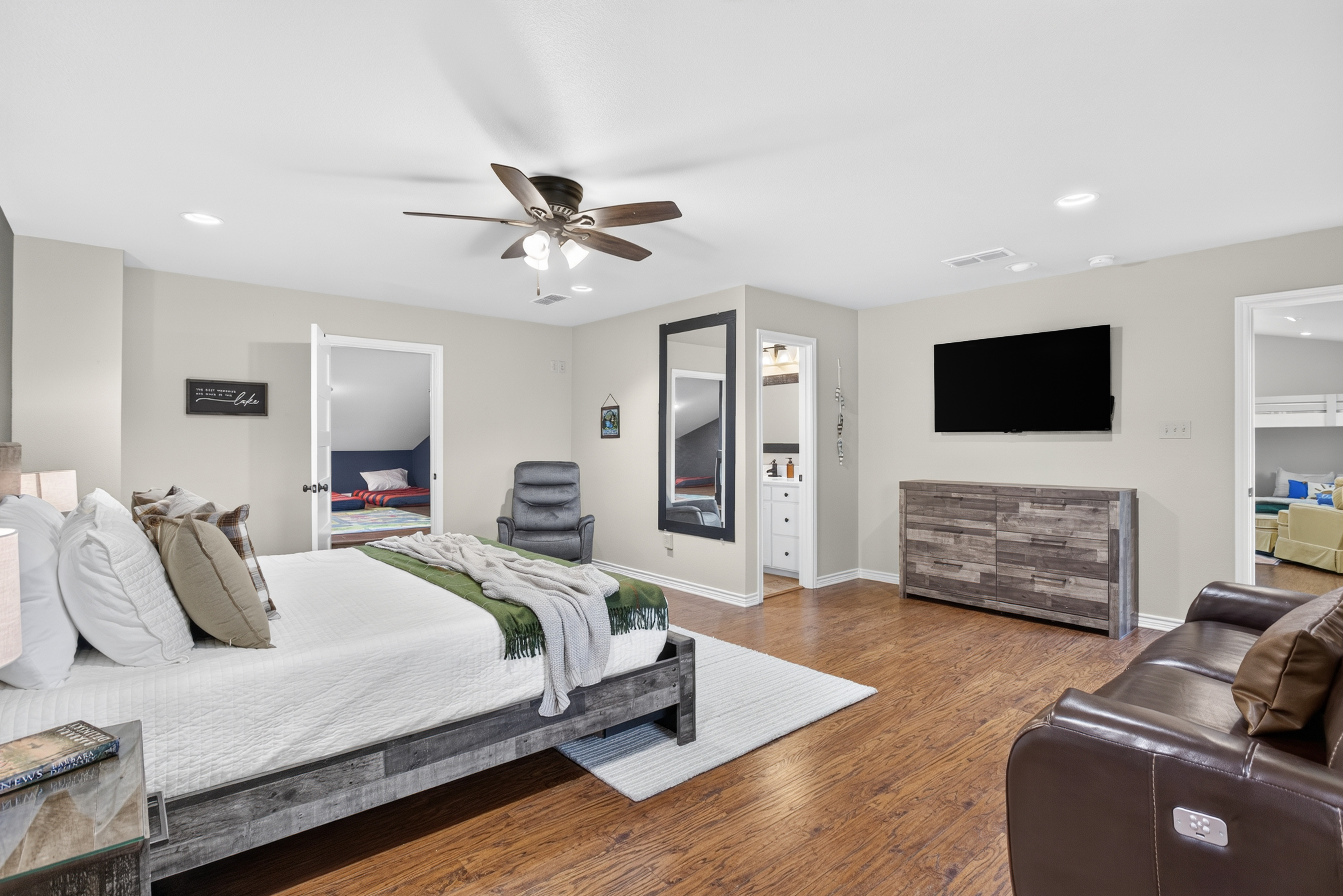 Spacious king bedroom with TV, seating, and warm modern style