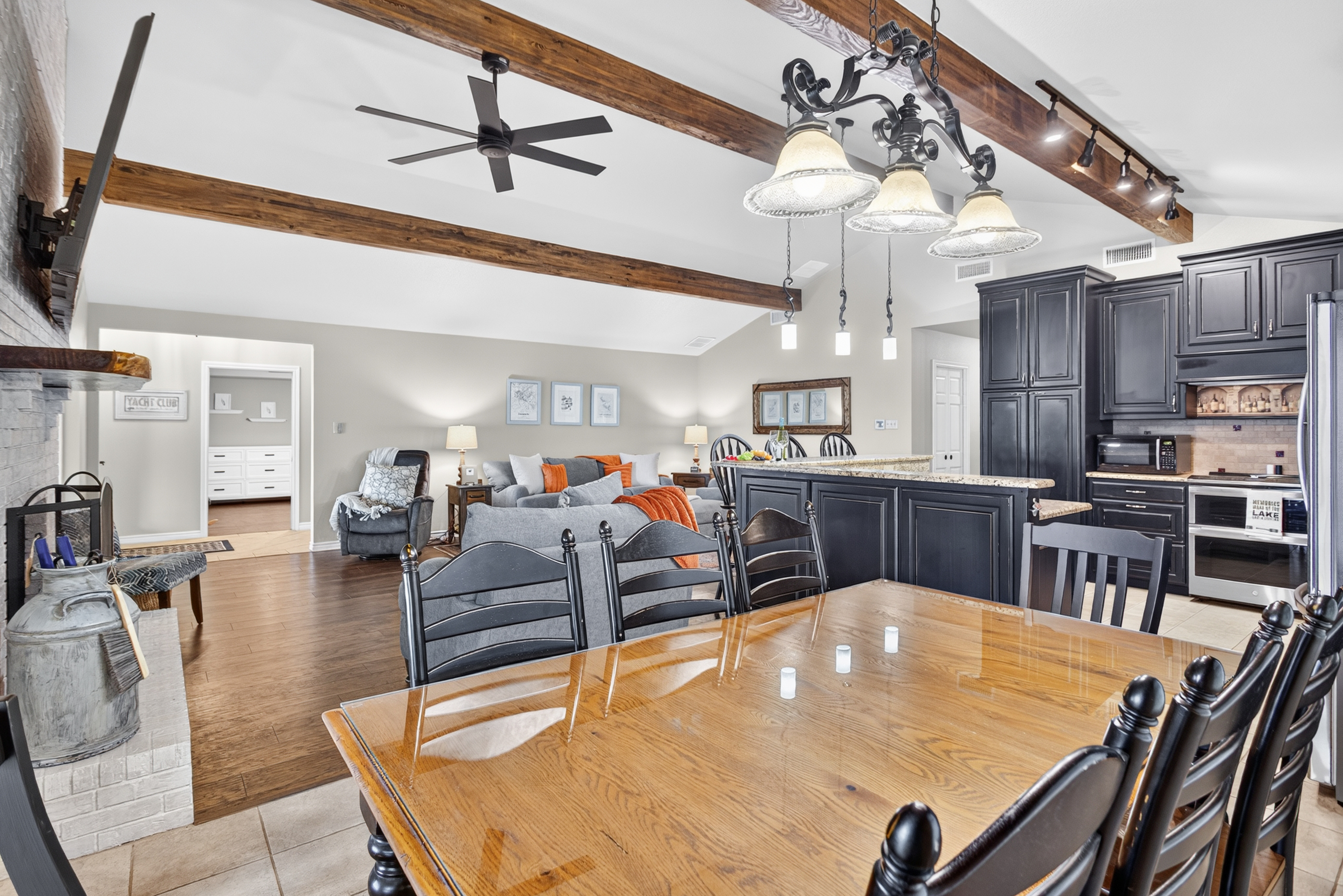 Open-concept great room with vaulted beams, island seating, and stylish kitchen