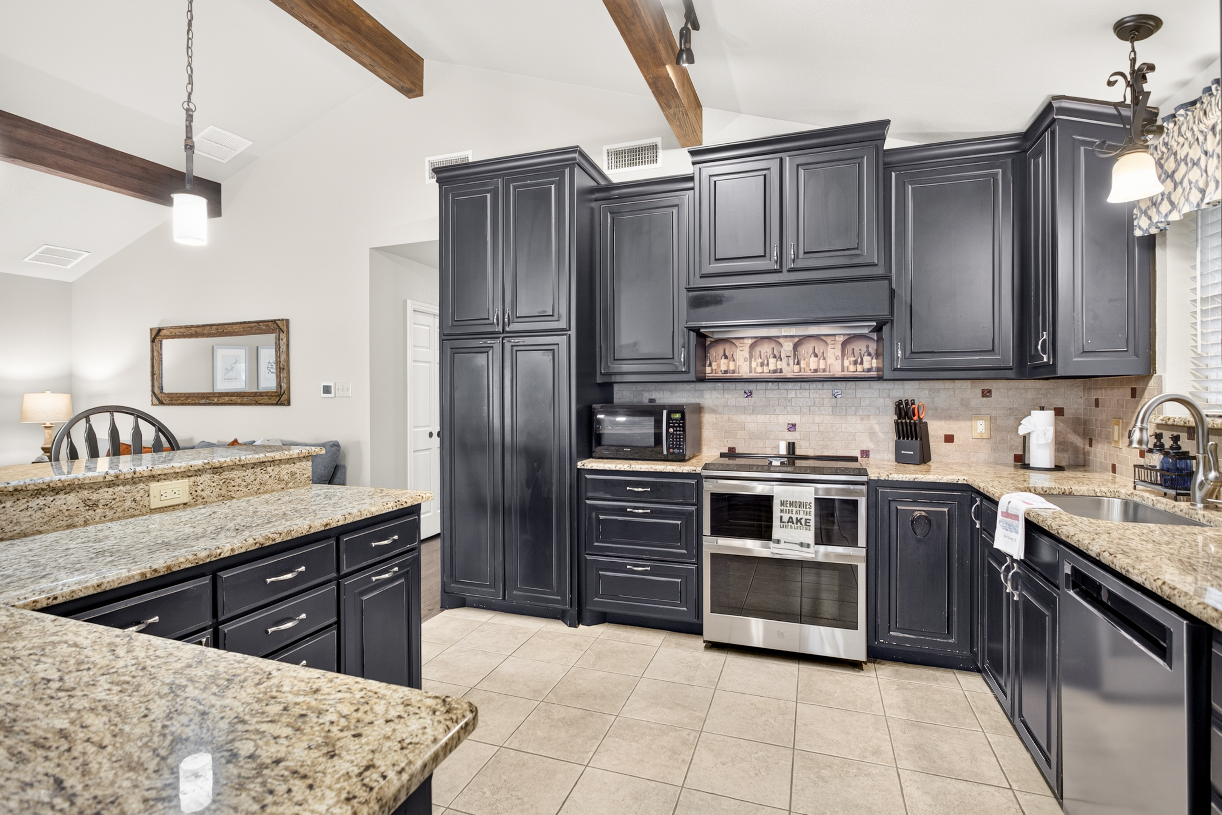 Spacious gourmet kitchen with granite counters and elegant dark cabinetry