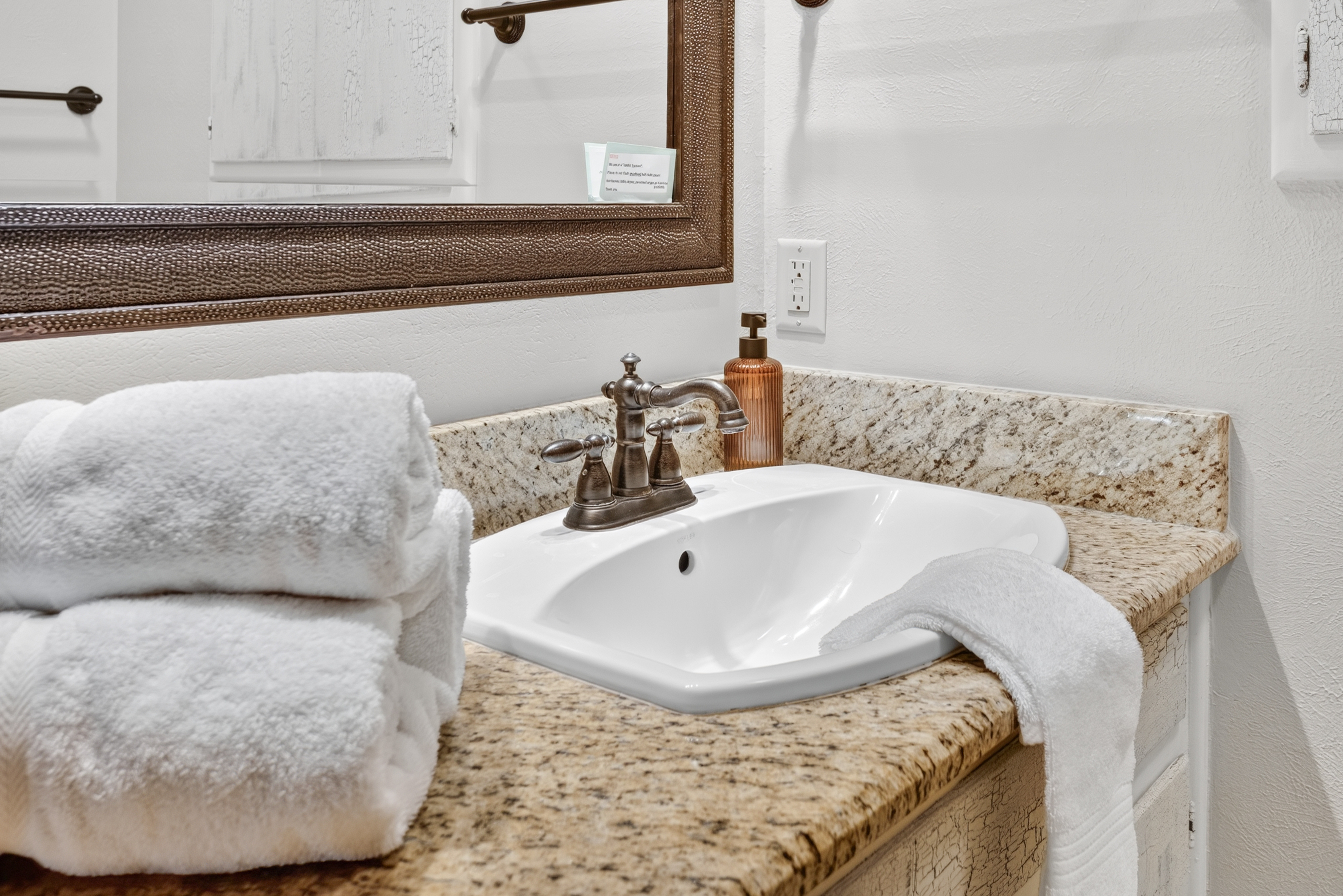 Granite vanity with plush towels and a clean, upscale bathroom feel