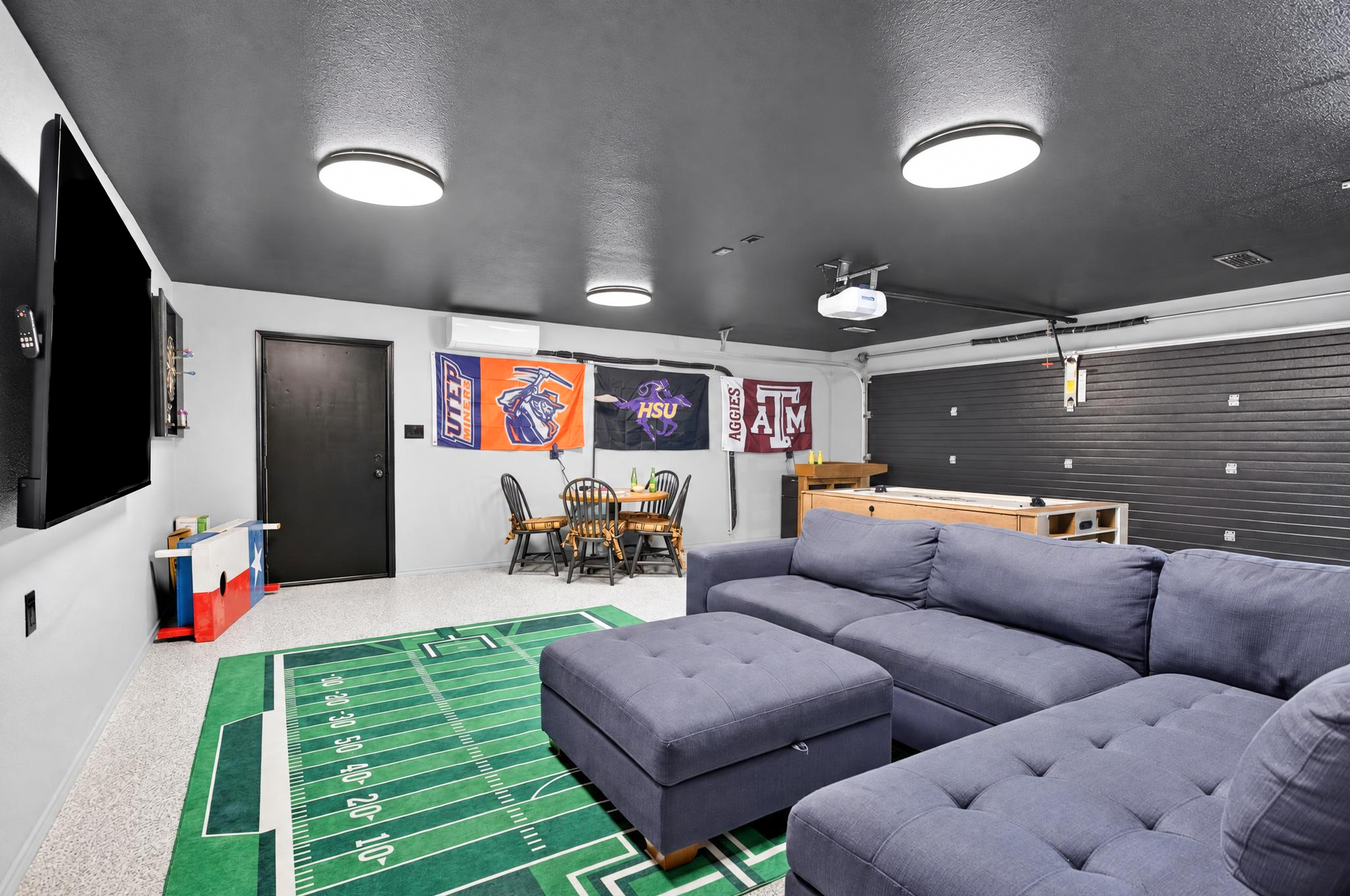 Game-day lounge with huge TV, sectional seating, and fun sports decor