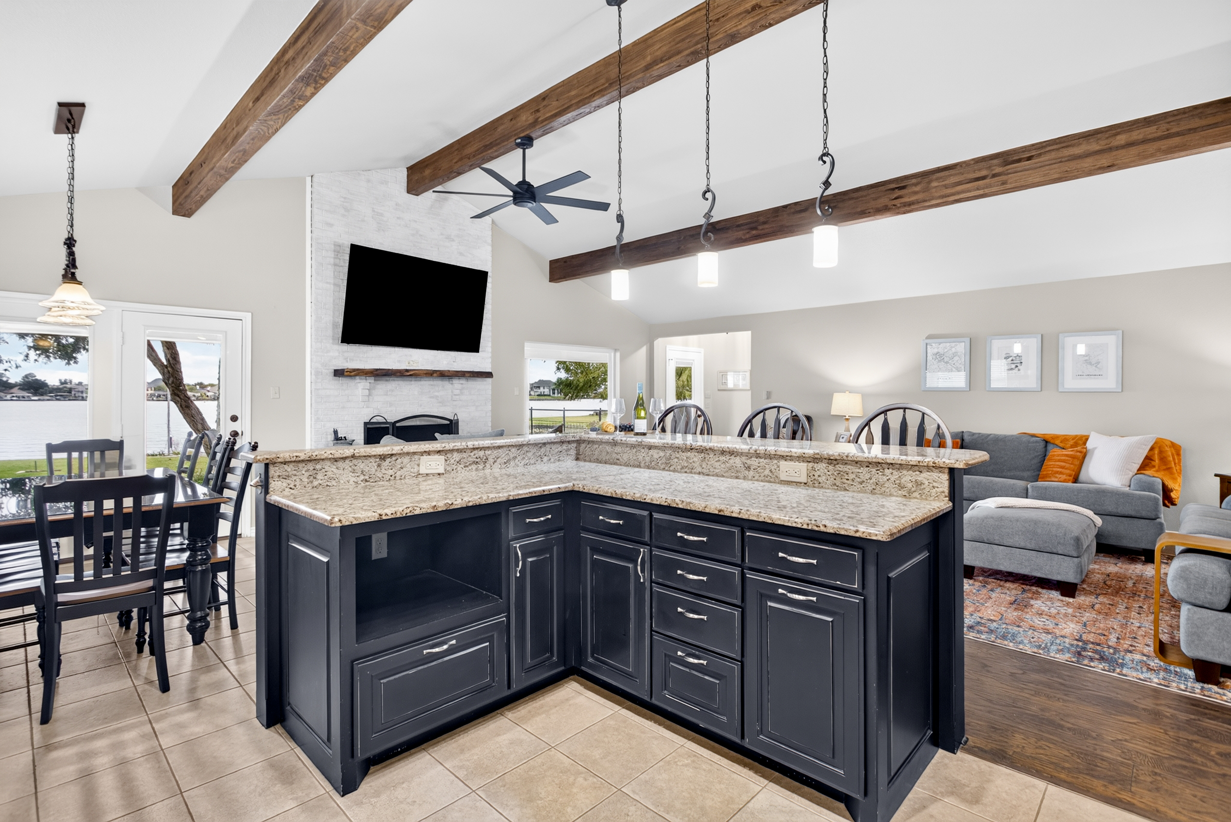 Open-concept kitchen and living area with beams and waterfront views