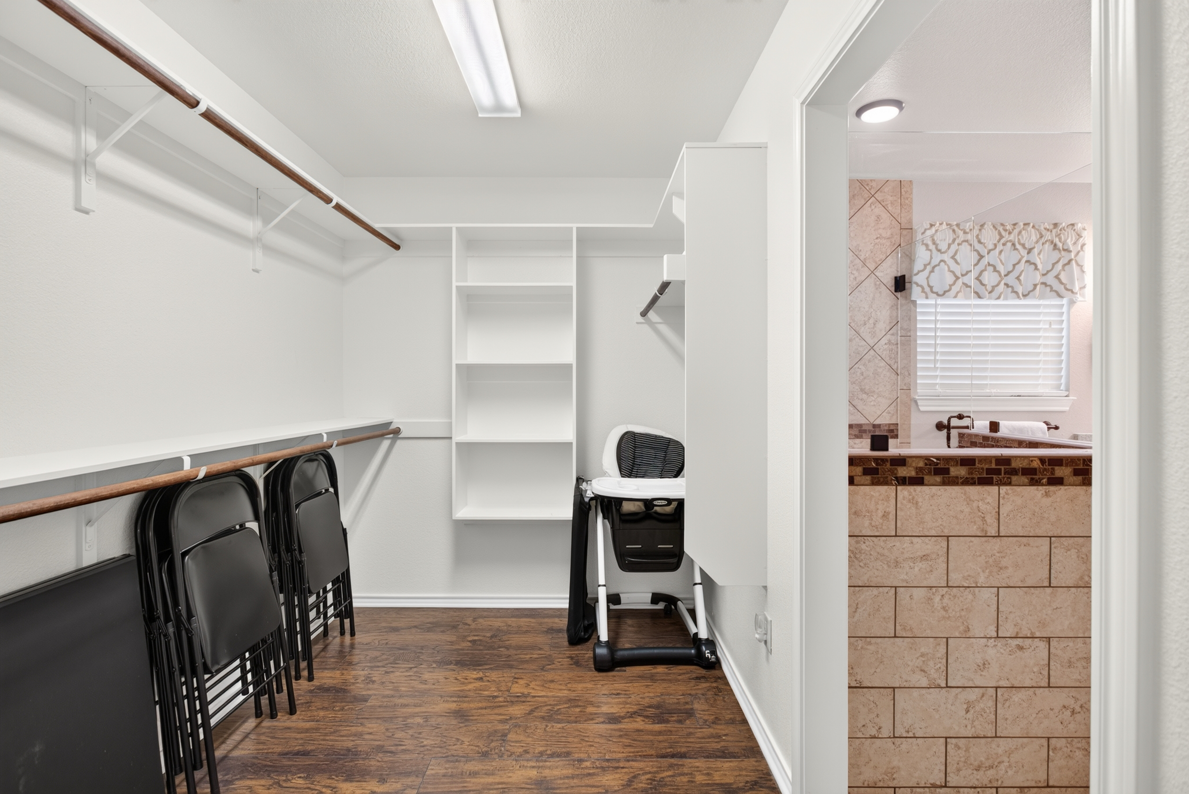 Spacious walk-in closet with built-in storage beside the bathroom