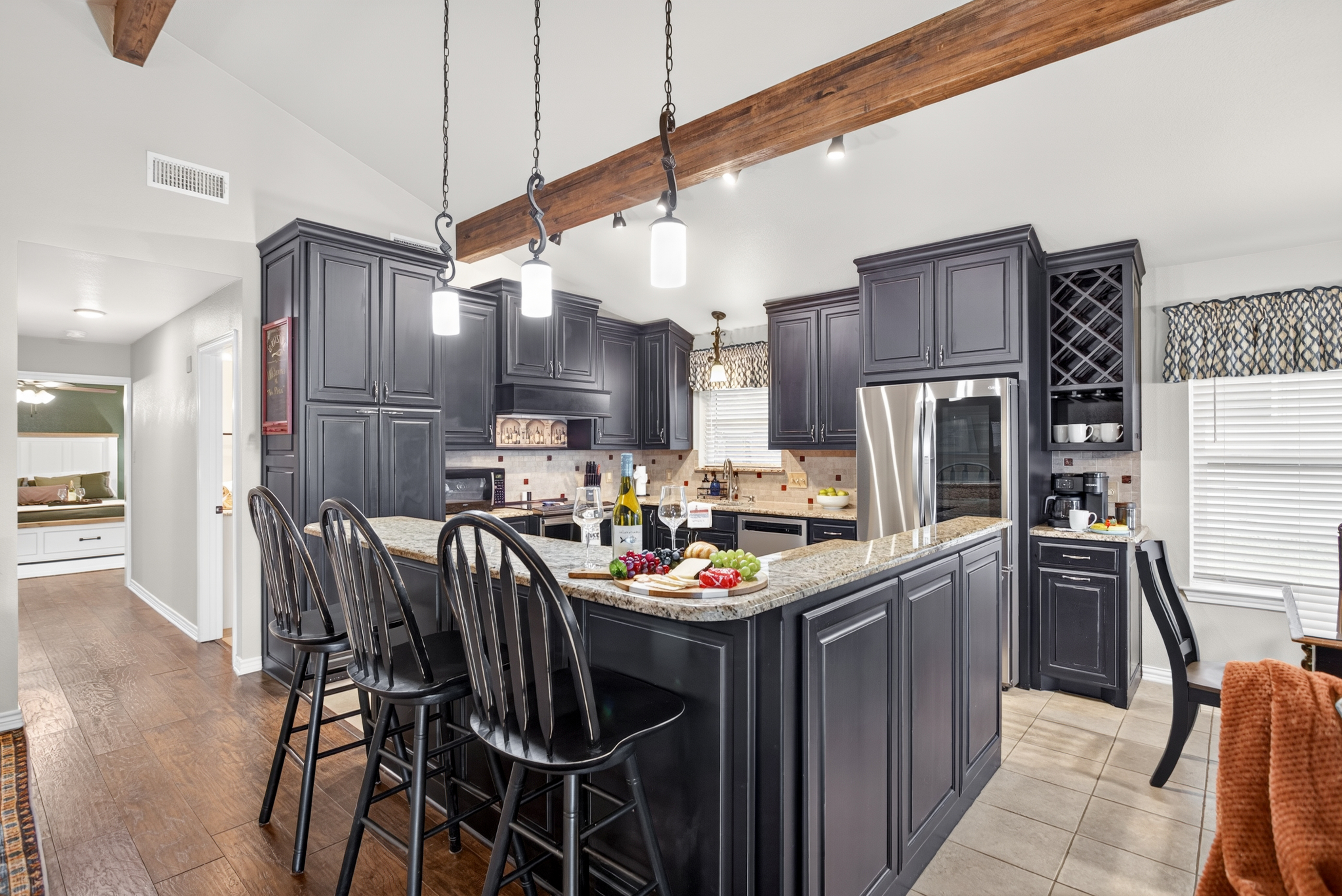Spacious gourmet kitchen with granite island, bar seating, and wine rack