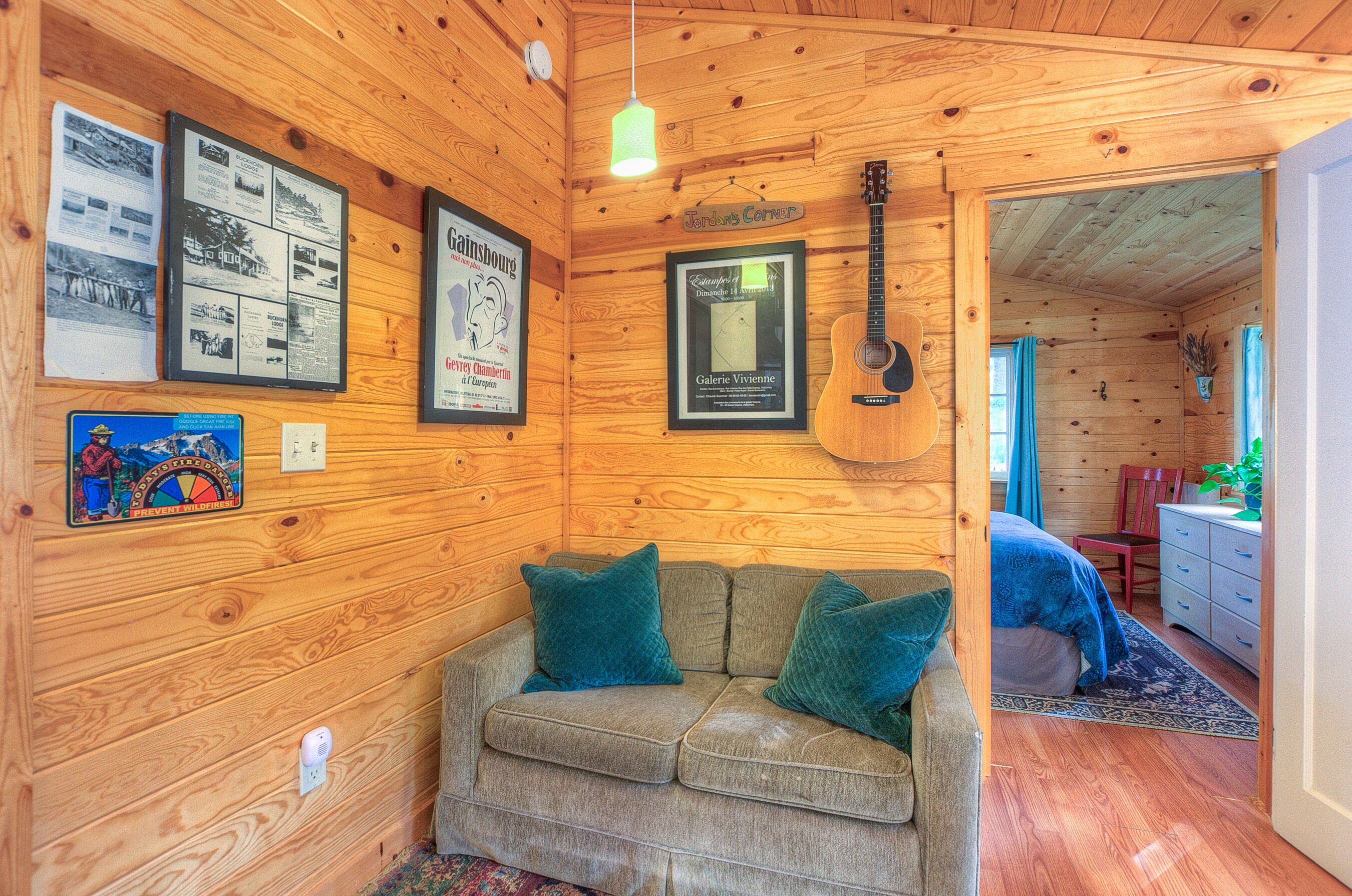 Kitchern love seat, guitar, and bedroom through door on right.