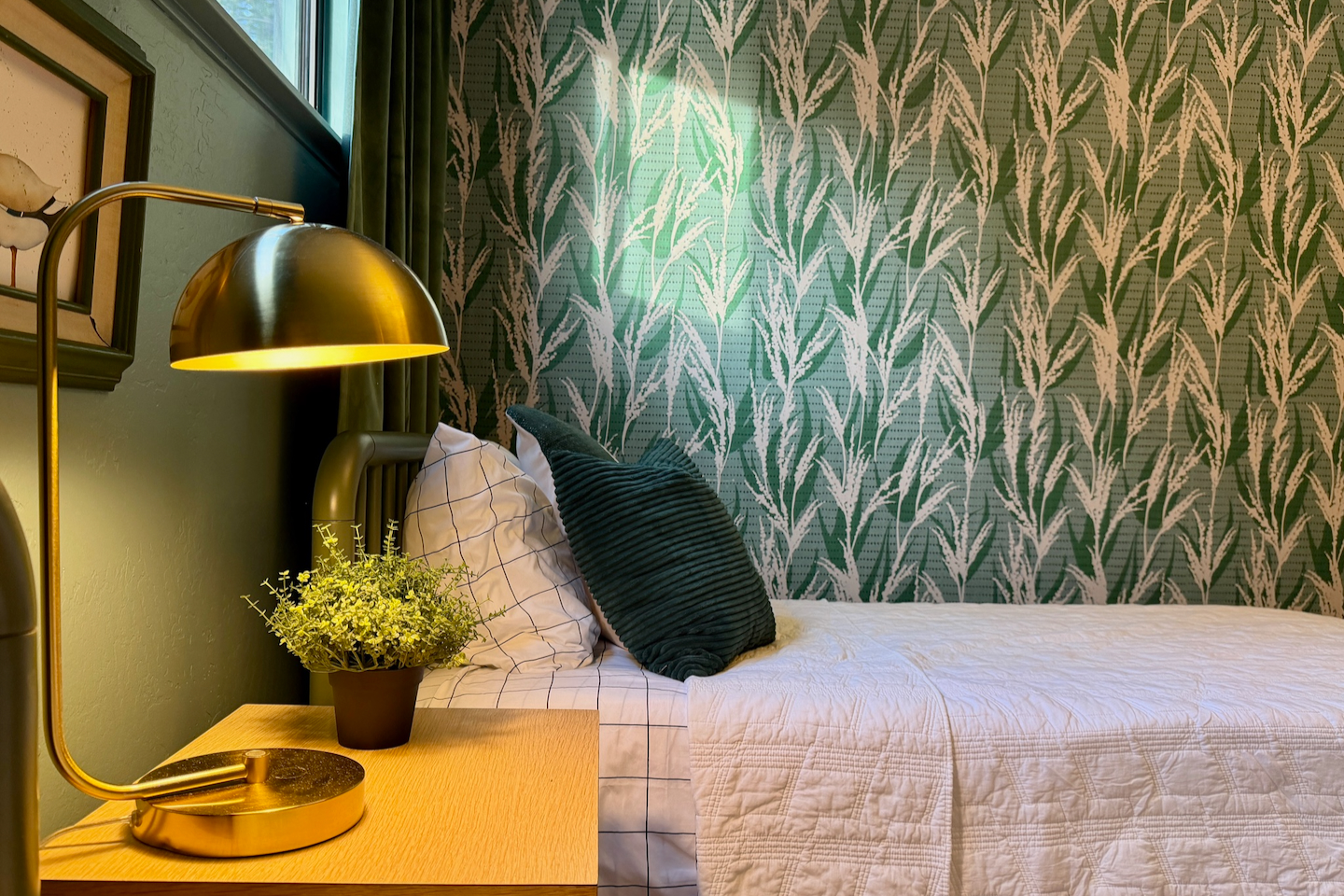 Cozy bedroom with botanical wallpaper and chic gold bedside lighting