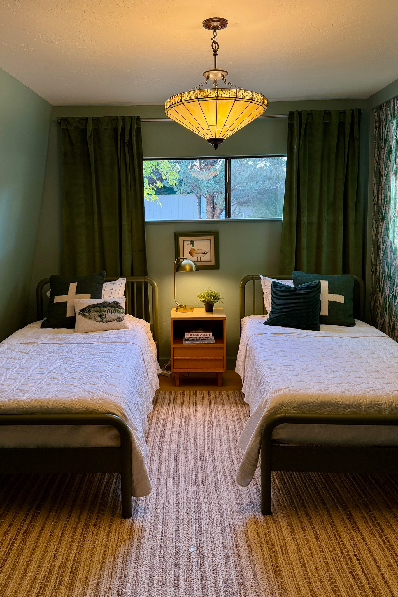 Charming twin bedroom with cozy beds, warm lighting, and serene green tones