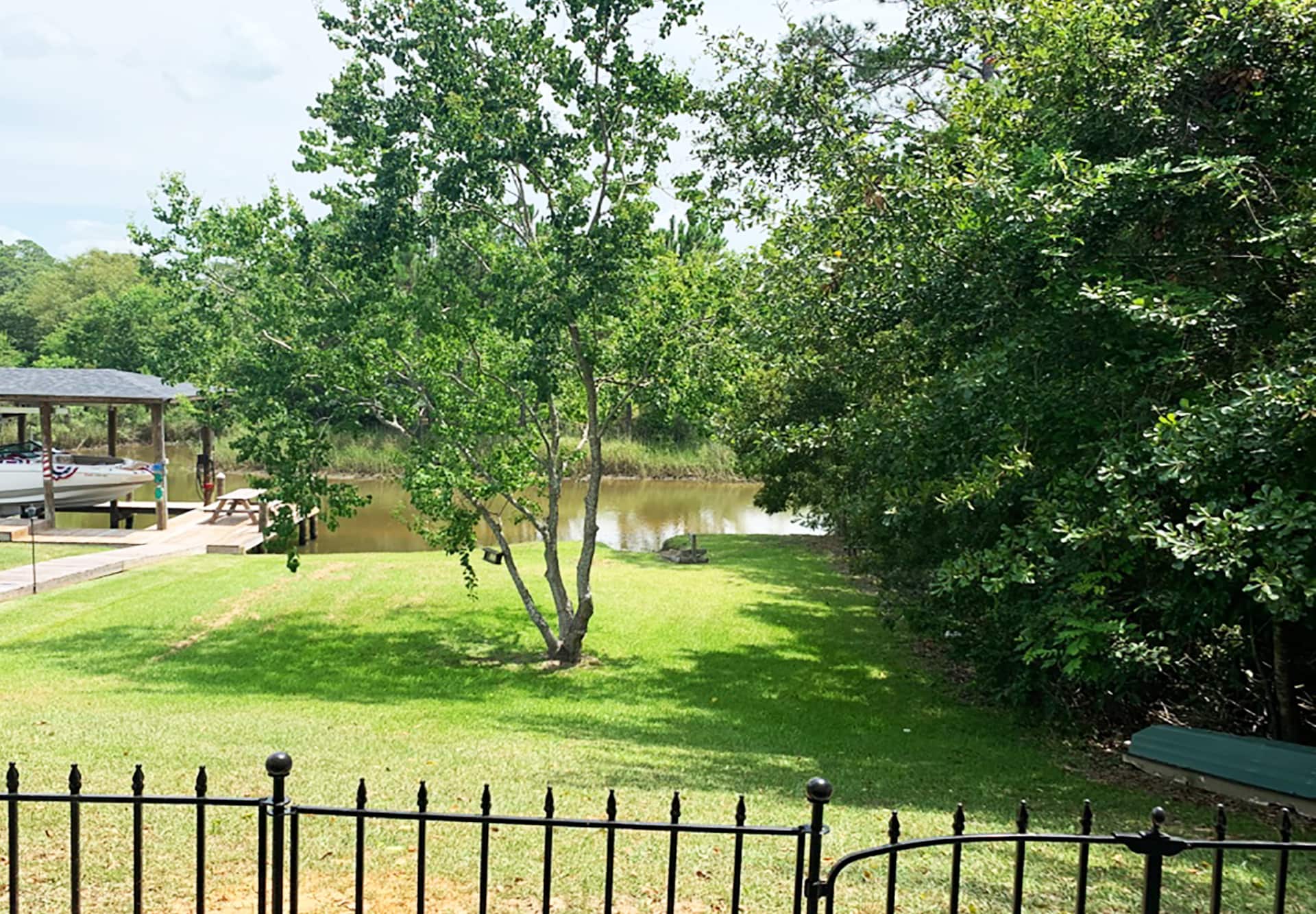 Private waterfront lawn with shady trees and easy dock access