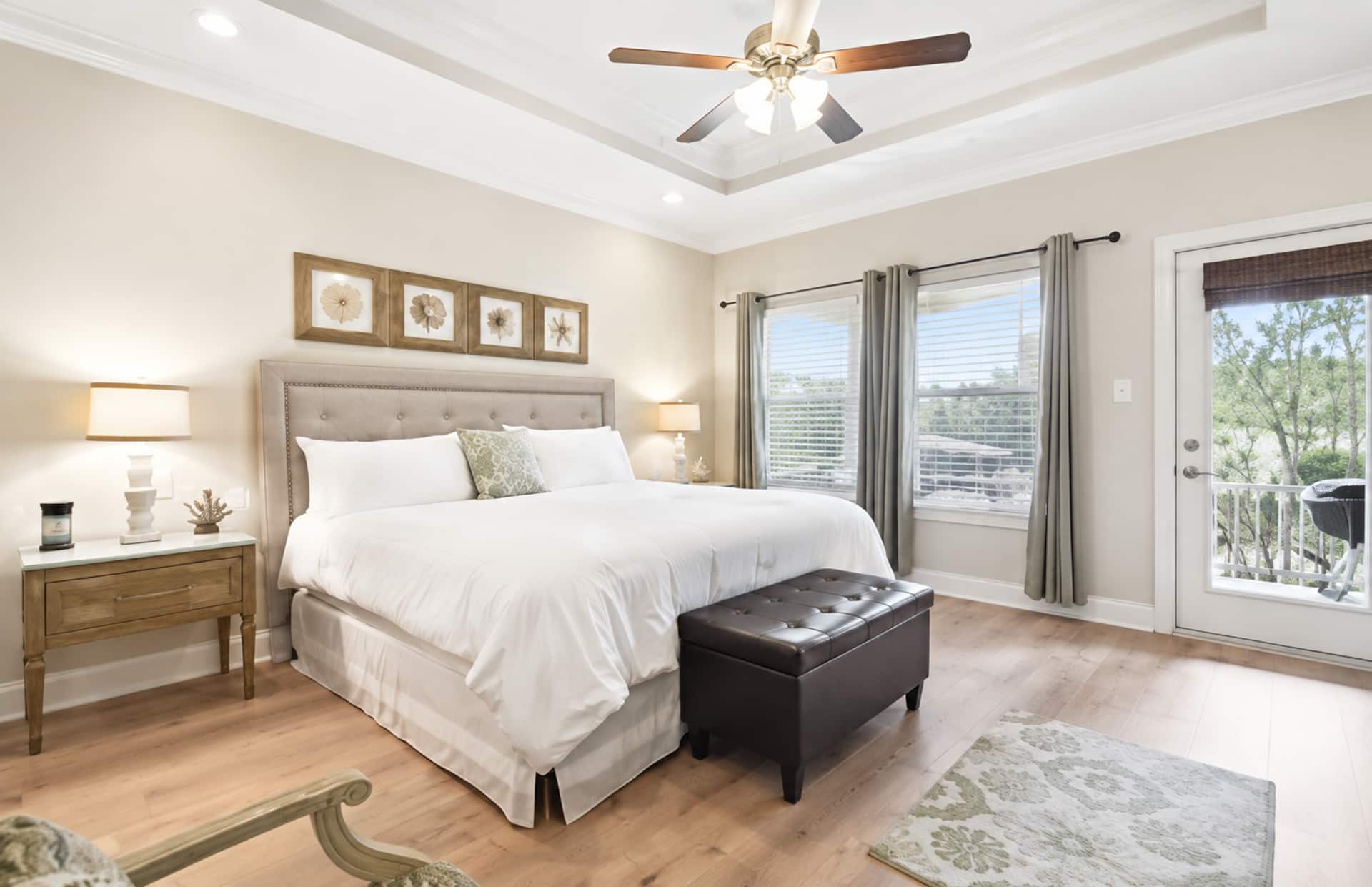 Bright king bedroom with balcony access and elegant tray ceiling