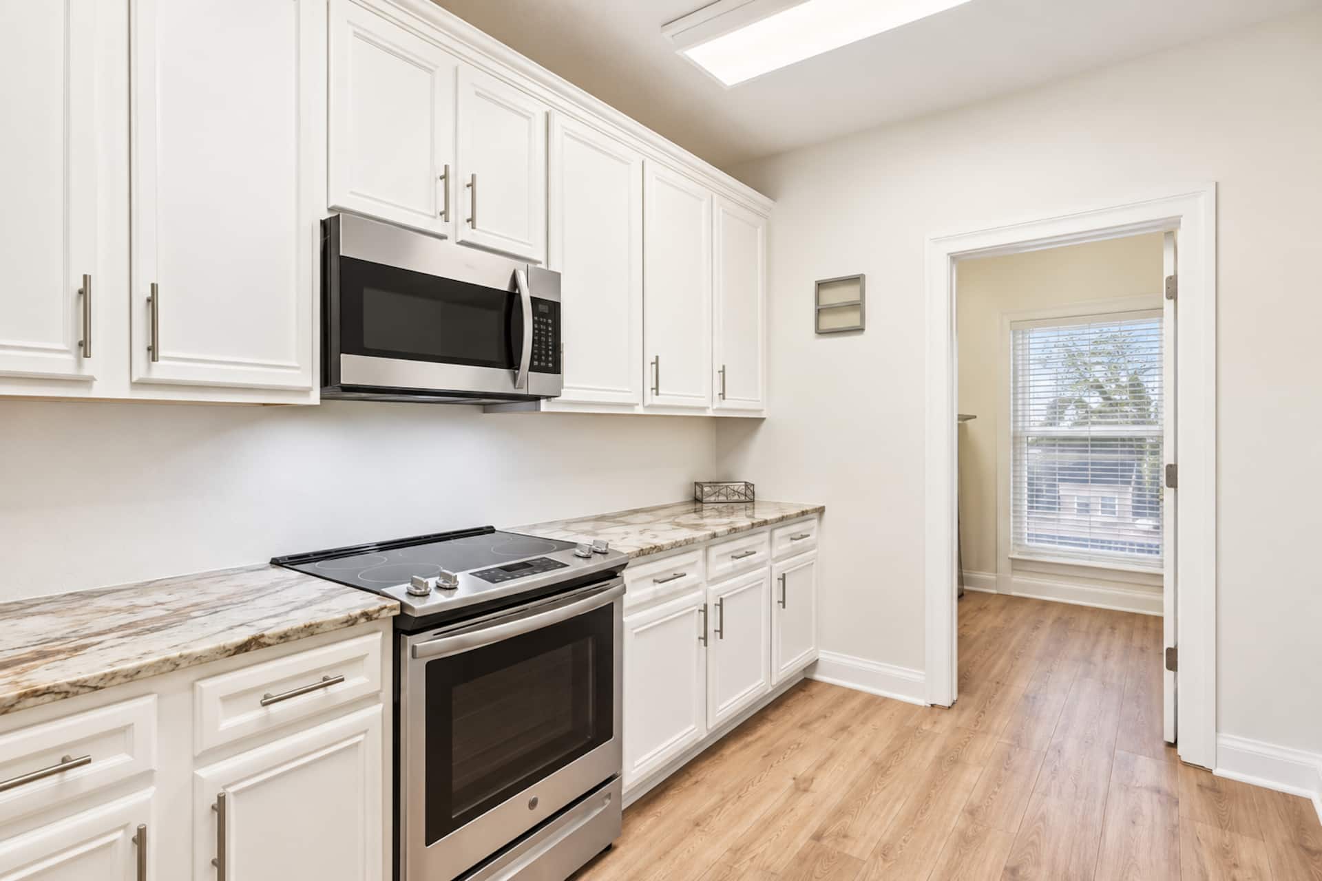 Bright modern kitchen with skylight, stainless appliances, and ample storage
