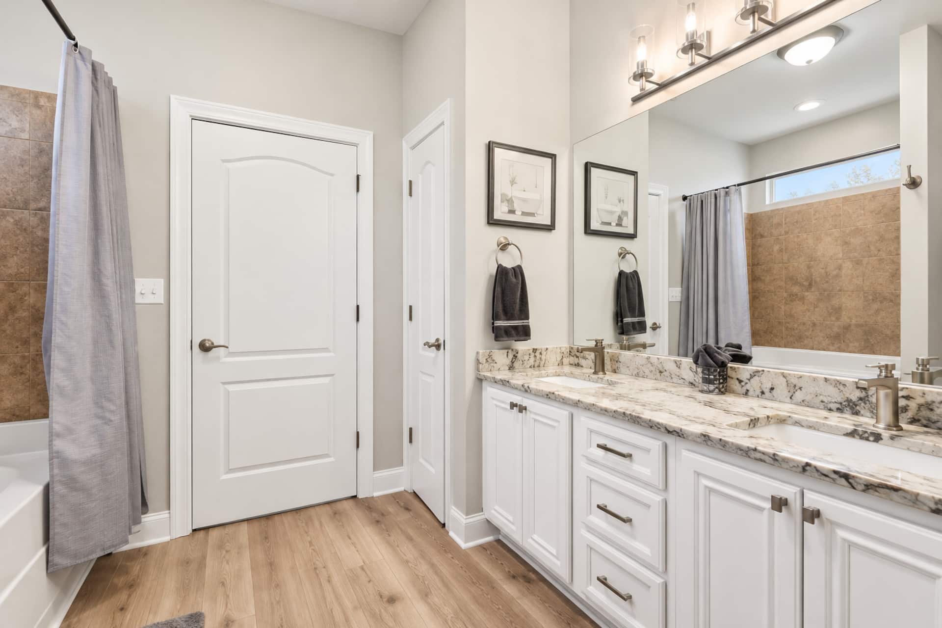 Bright modern bathroom with double vanity and granite countertops