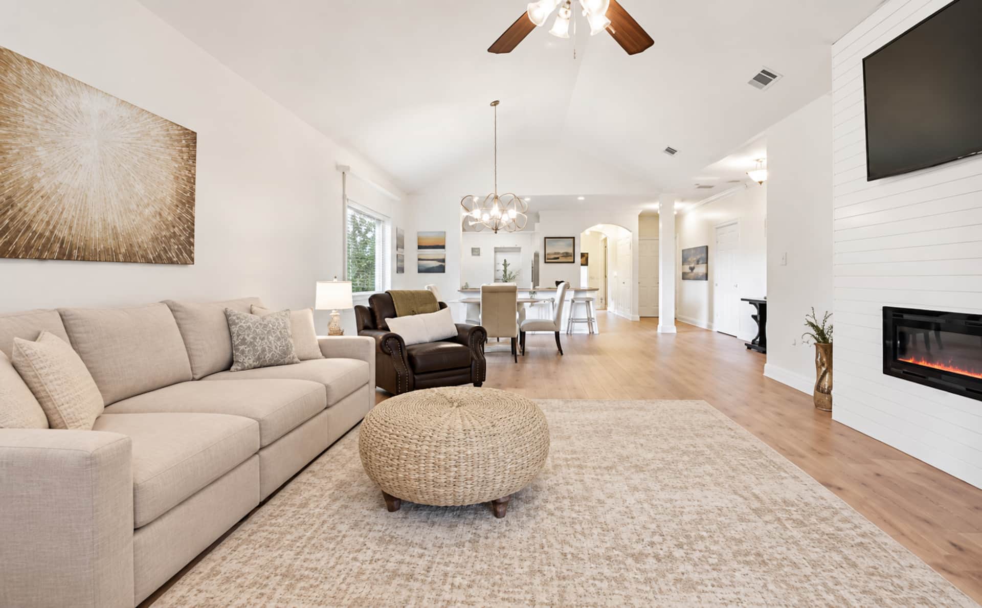 Bright open living space with fireplace, TV, and seamless dining area