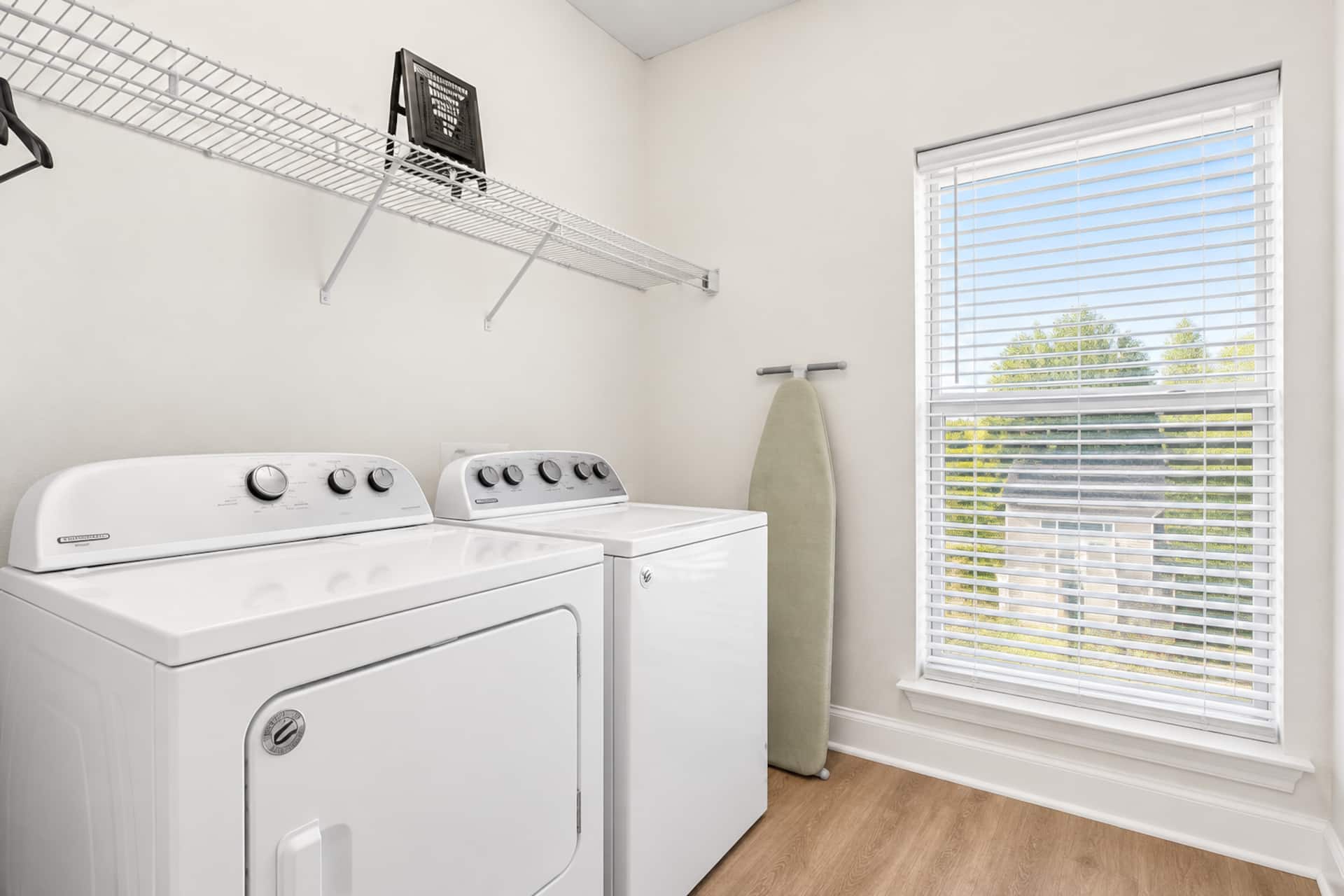 Bright laundry room with full-size washer, dryer, and natural light
