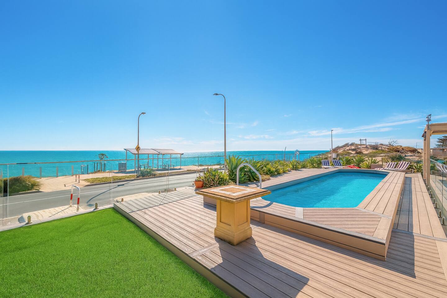 Lawn, deck and private oceanfront pool with the boardwalk beyond