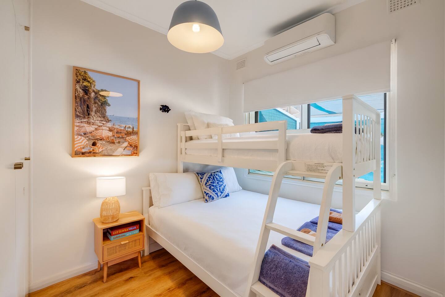 Bunk room with cosy bedding and glimpses of the ocean