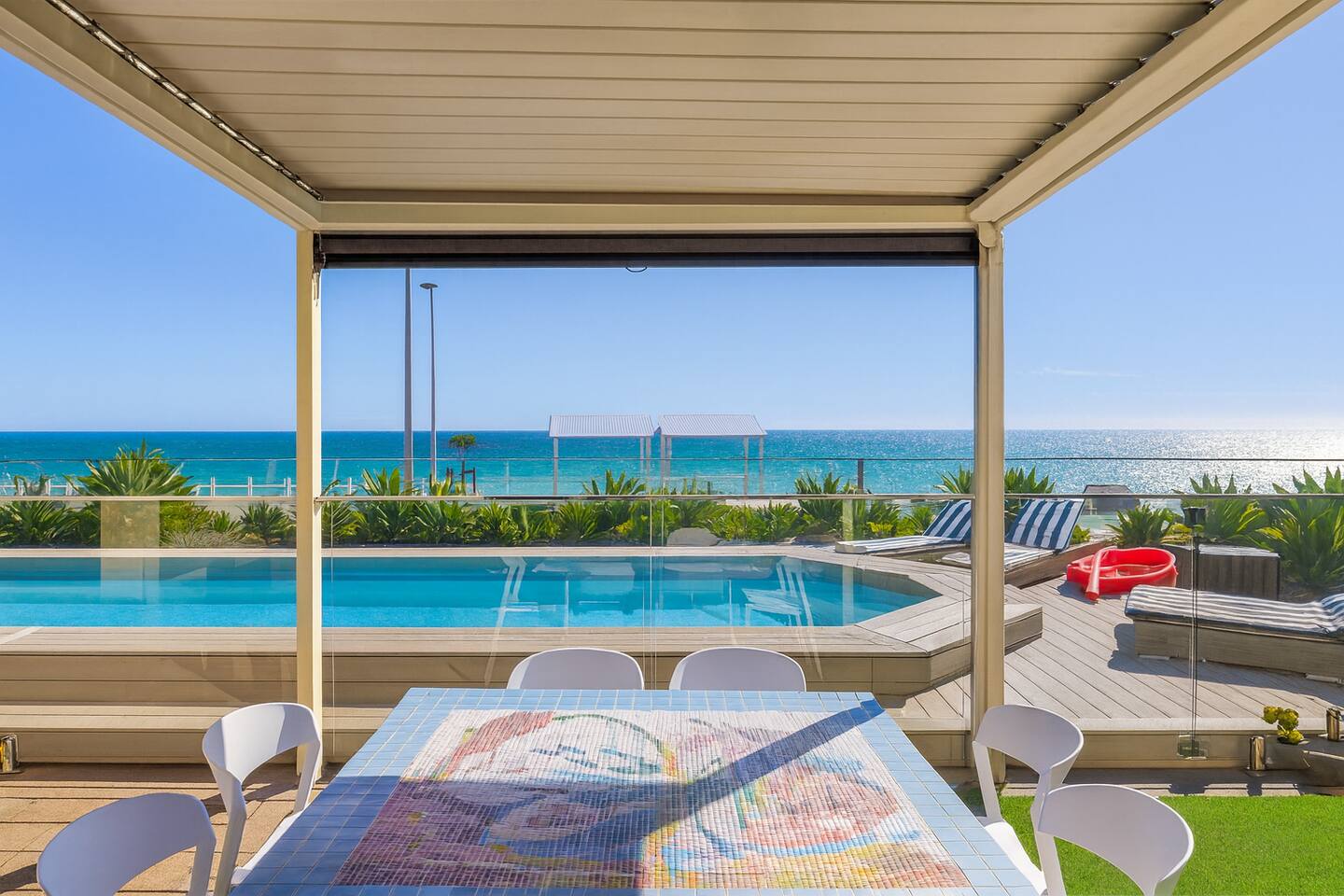 Poolside pergola with mosaic tables and ocean views