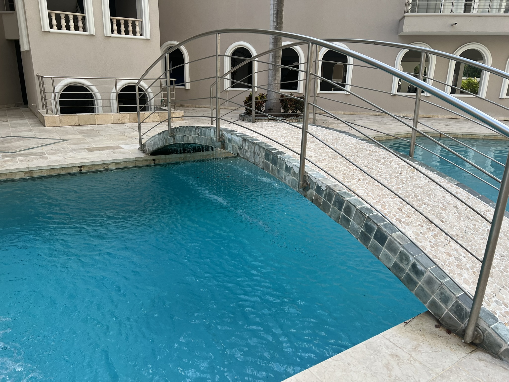 Elegant pool with arched bridge and a chic resort-style setting