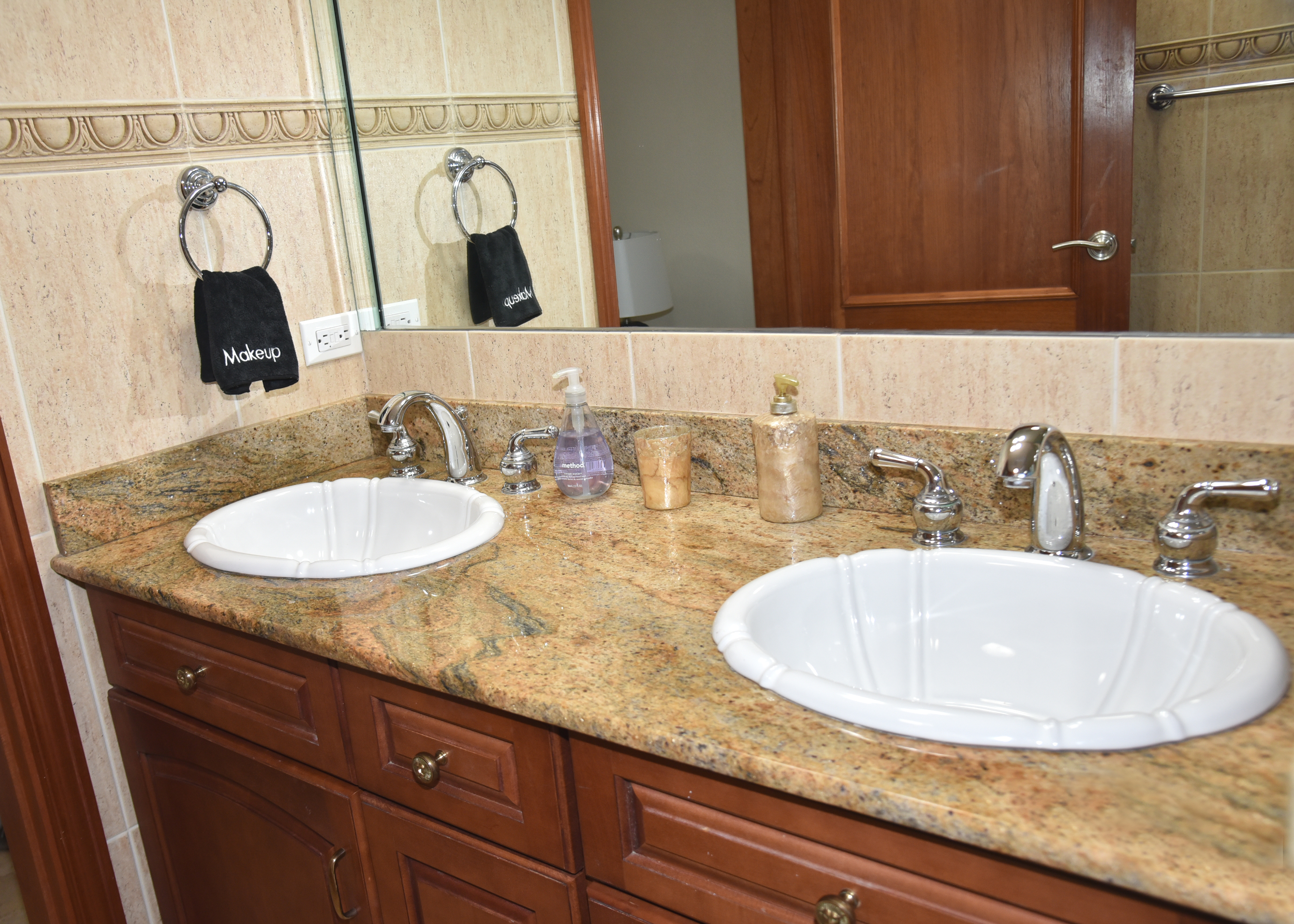 Spacious double-sink vanity with granite counters and elegant finishes