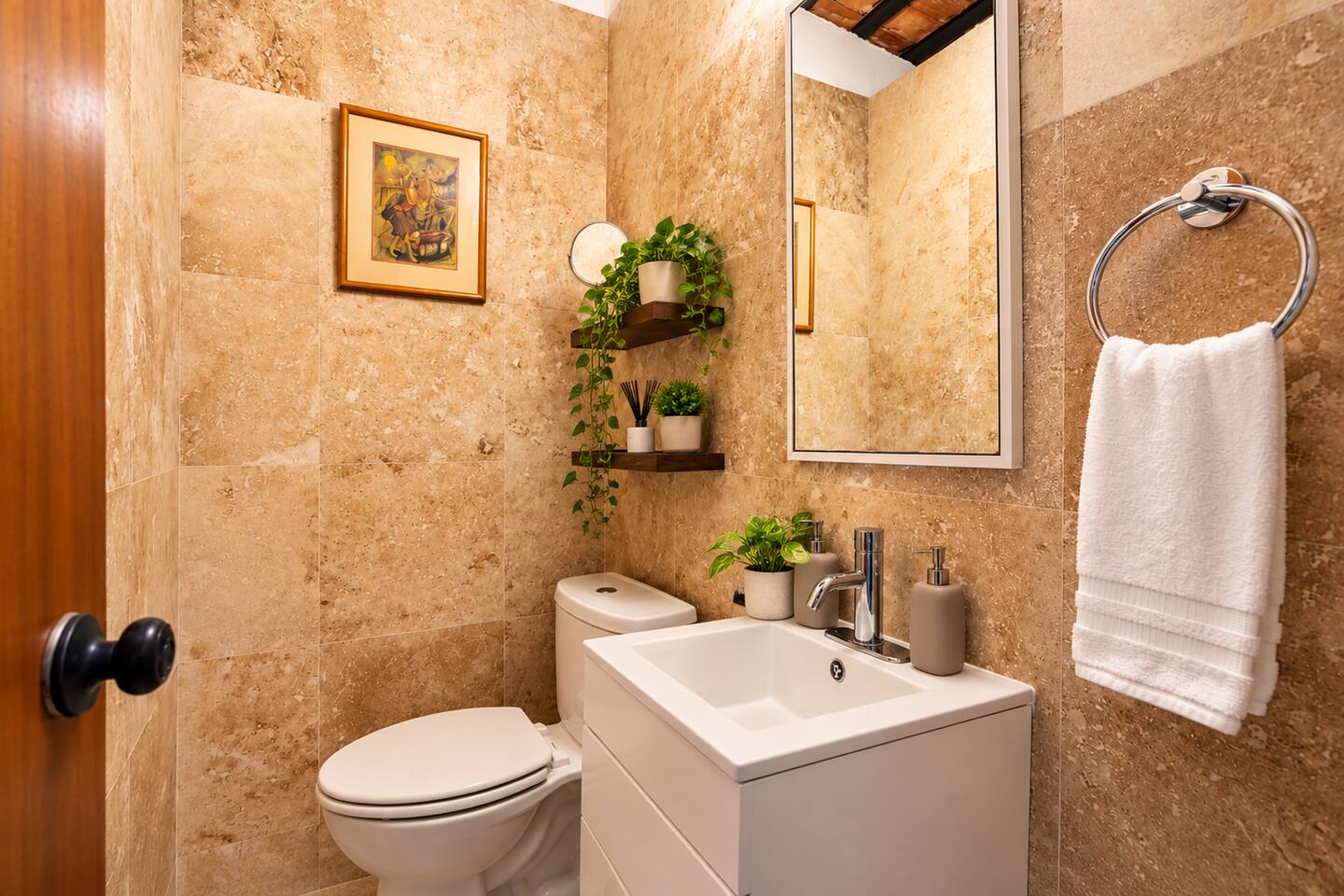 No need to head downstairs! This half bathroom is located beside the upstairs Queen bedroom. Featuring natural stone tile, a modern vanity, and thoughtful touches, it adds comfort and convenience when sharing the loft with friends or family.