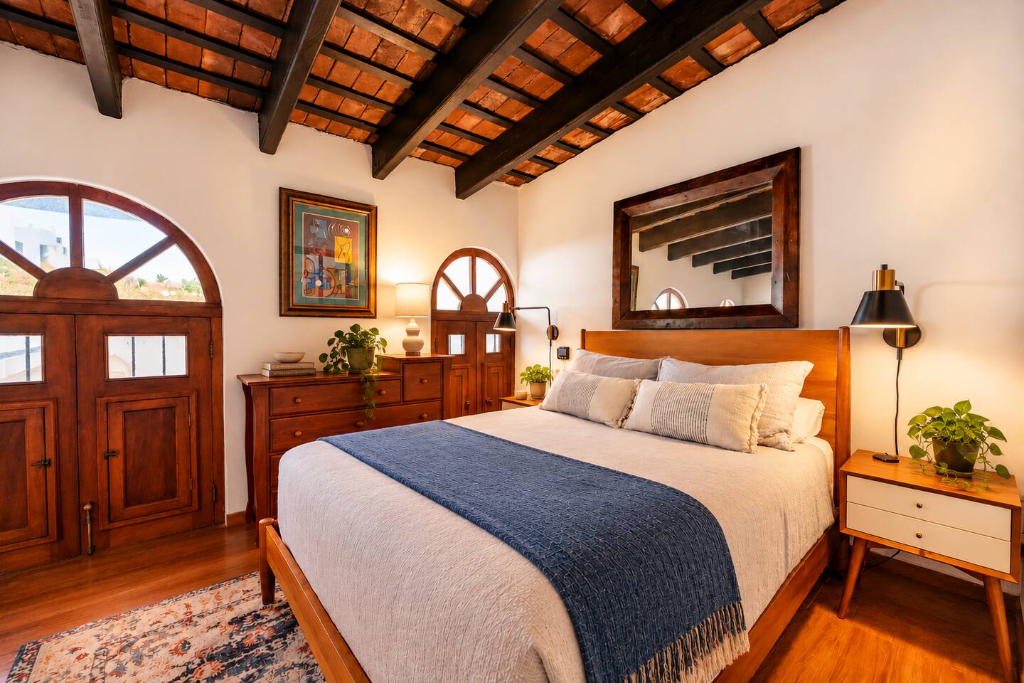 Step back in time without sacrificing comfort! Beautiful arched wooden windows, original exposed beams, and warm wood furnishings give this loft Queen bedroom its authentic Old San Juan charm. A cozy retreat after a day exploring the city.