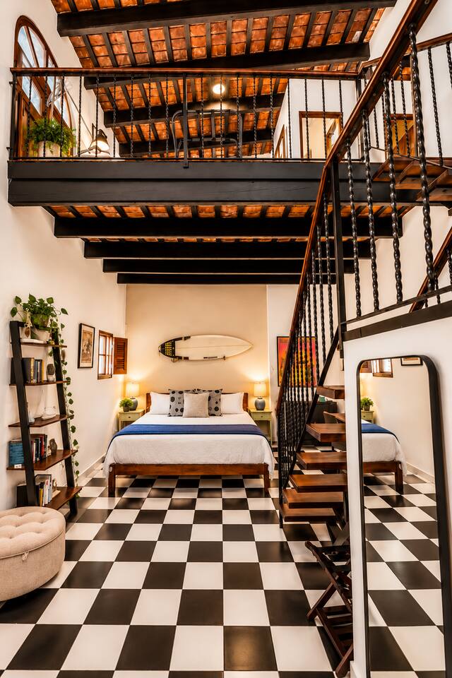 One apartment, two sleeping levels! The downstairs King bedroom and upstairs Queen bedroom are connected by an open staircase beneath soaring ceilings and exposed wooden beams. A unique layout for friends & families sharing an Old San Juan adventure.