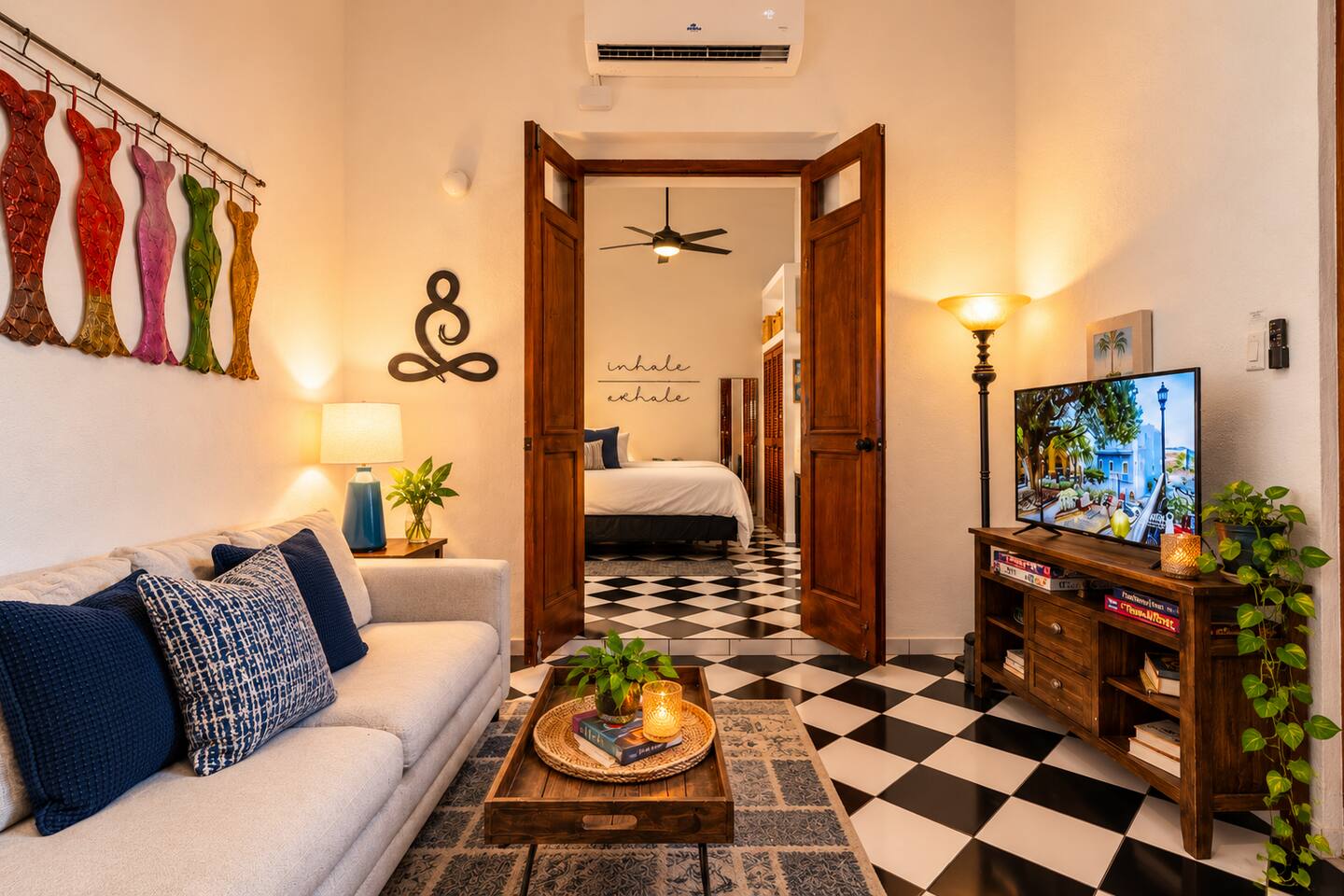 Peaceful living area opening into the King bedroom, with soaring 18-ft ceilings, authentic Spanish Colonial character, A/C, Smart TV, and a sofa that accommodates one additional guest.