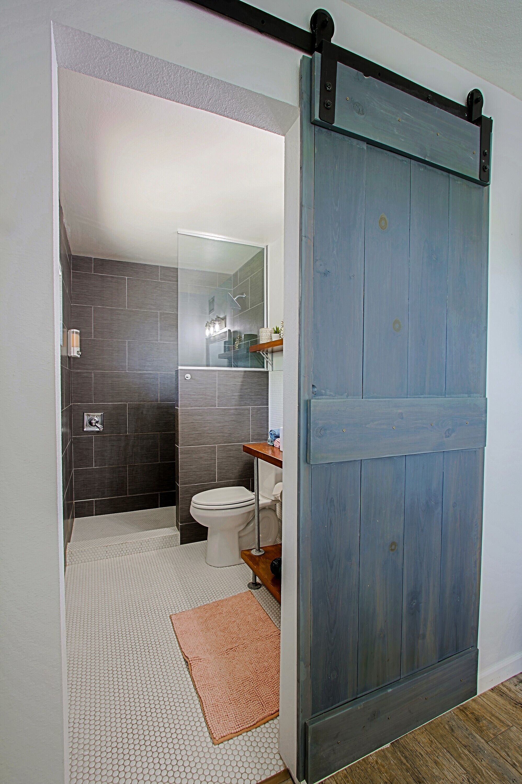 Wide shot of the primary suite bathroom and cool barn door. Good Vibes!