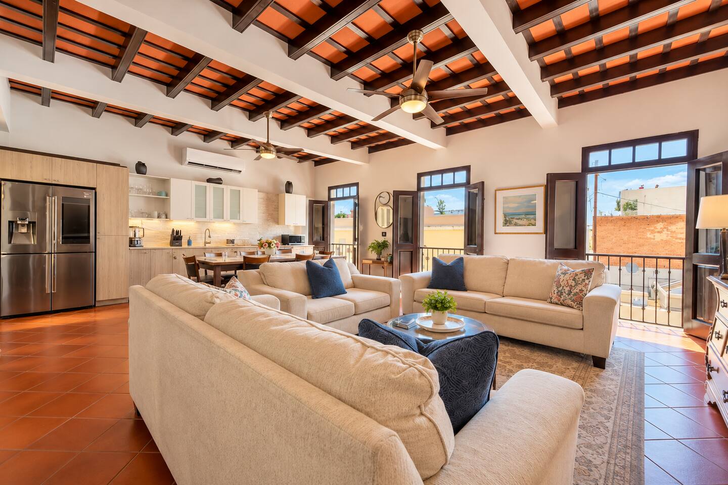 Relax in this spacious, sun-filled living room with comfortable sofas, Smart TV, A/C, and beautiful exposed-beam ceilings. Open French doors bring Old San Juan’s charm inside, while the adjoining kitchen and dining area are perfect for gathering.