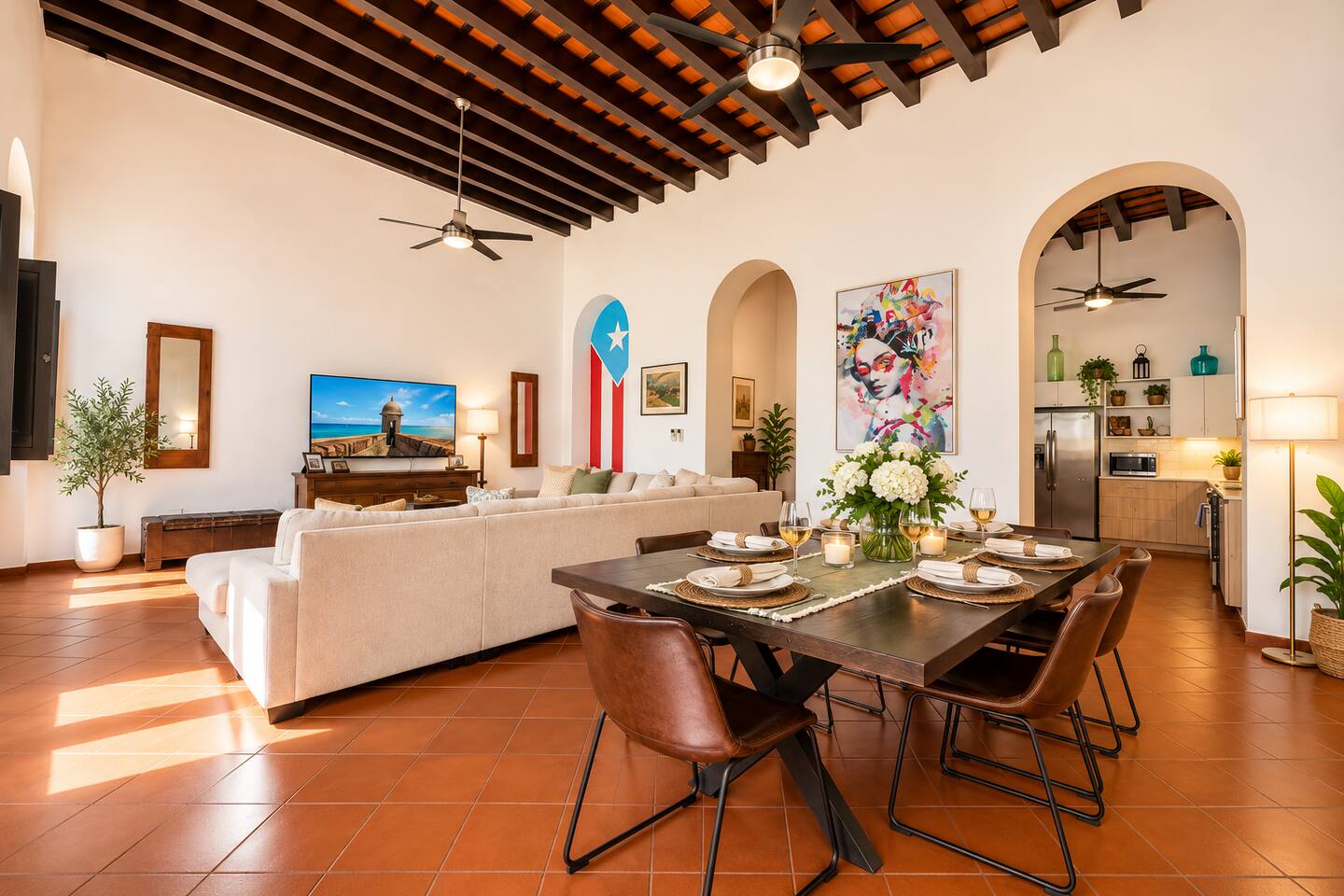 Gather in this spacious, sun-filled living and dining area featuring soaring ceilings, exposed wooden beams, and vibrant Puerto Rican artwork. Relax on the plush sectional, share meals around the dining table, and enjoy the charm of Old San Juan.