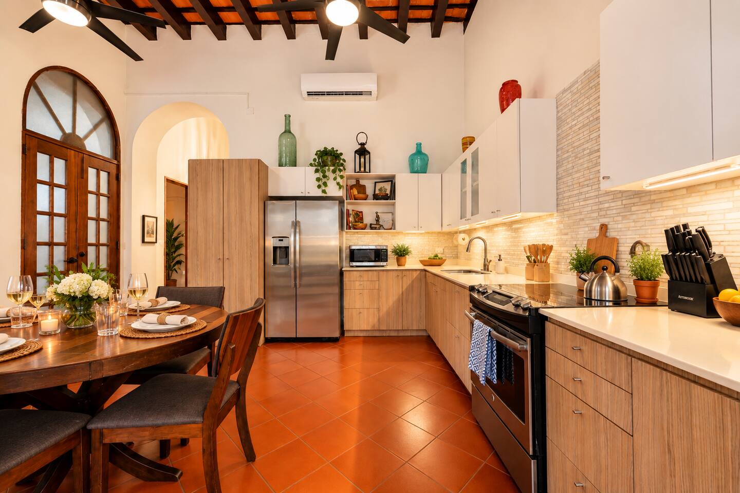 Cook, dine, and gather in this spacious, equipped kitchen featuring stainless steel appliances, generous counter space, & a cozy dining area. High ceilings, exposed wooden beams, and terracotta floors bring authentic Old San Juan charm to every meal.