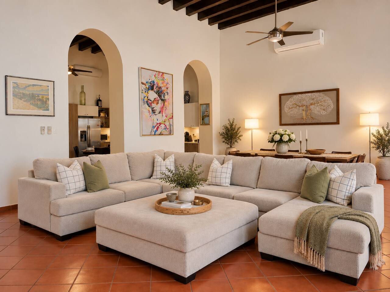 Unwind in the spacious living room featuring soaring ceilings, exposed wood beams, a plush sectional, Smart TV, and A/C. The adjoining dining area offers plenty of room to gather, share meals, and relax after exploring Old San Juan.