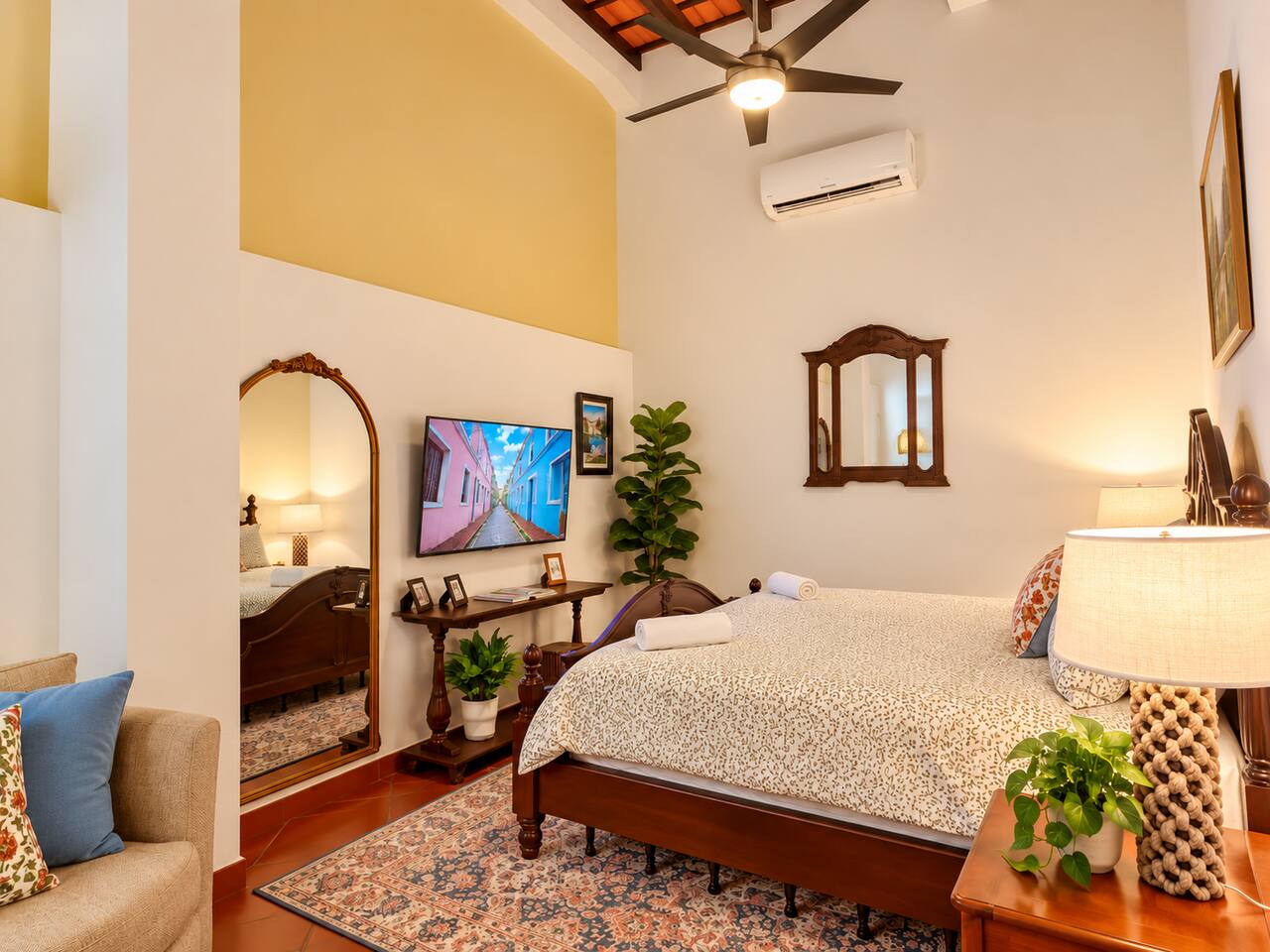 Relax in this spacious, inviting bedroom featuring soaring ceilings, charming exposed wood beams, a king bed, Smart TV, A/C, and a cozy sitting area—the perfect retreat after exploring Old San Juan.