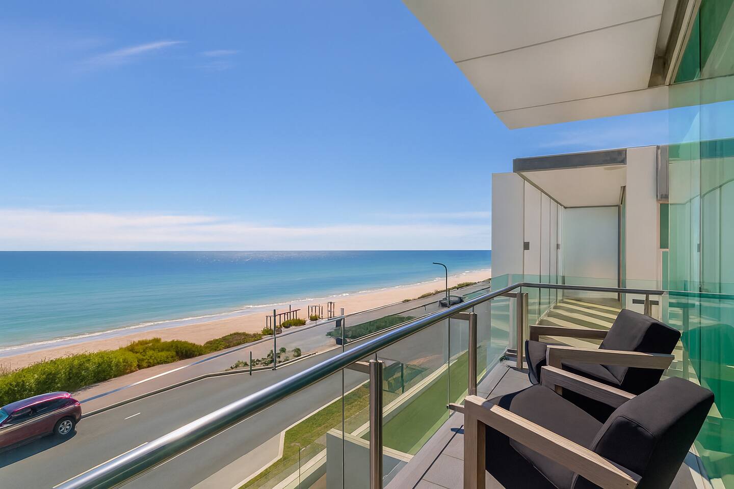 Bedroom with glass doors and private balcony over turquoise water