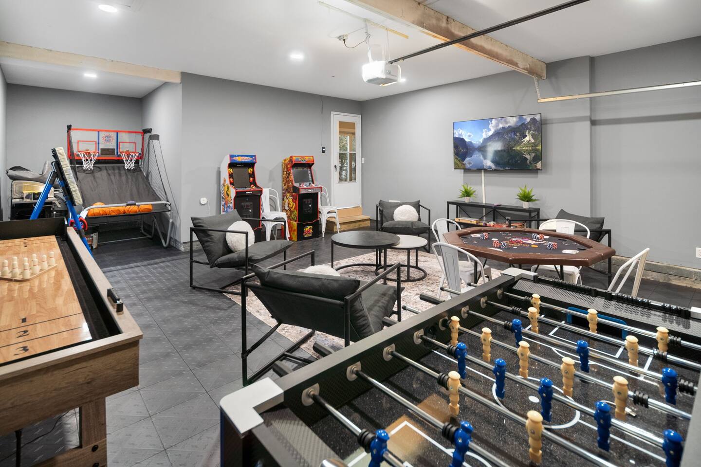 Heated garage game room with arcade, basketball, shuffleboard and foosball
